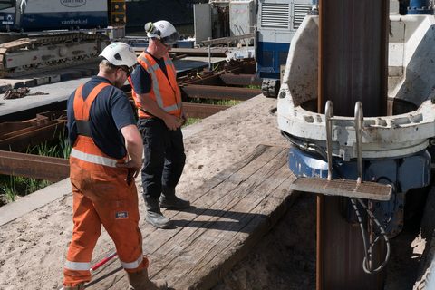 河岸の矢板打設を進める作業員