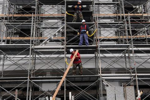 建物の外壁に組まれた足場で作業する職人